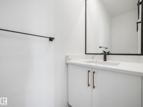 Bathroom vanity with white cabinetry, bronze hardware, and a white countertop - 6125 Crawford Drive, Edmonton, AB - Indoor Photo Showing Bathroom