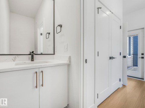 Bathroom vanity featuring a rectangular undermount sink, a dark bronze single-handle faucet, and a large framed mirror - 6125 Crawford Drive, Edmonton, AB - Indoor