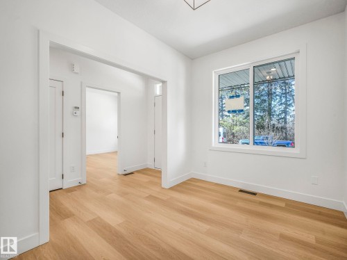 Bright interior space featuring wood-finish flooring, white walls, and white trim throughout - 6125 Crawford Drive, Edmonton, AB - Indoor Photo Showing Other Room