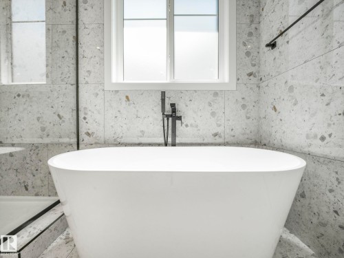 Freestanding soaking tub with a floor-mounted matte black faucet - 6125 Crawford Drive, Edmonton, AB - Indoor Photo Showing Bathroom