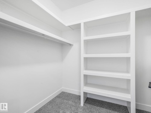 Closet featuring built-in shelving, hanging rod, and gray carpet - 6125 Crawford Drive, Edmonton, AB - Indoor With Storage