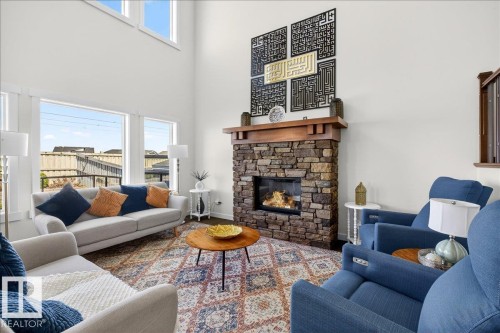 Vaulted ceilings accentuating a stone-clad fireplace with a wood mantle - 3936 Claxton Loop, Edmonton, AB - Indoor Photo Showing Living Room With Fireplace