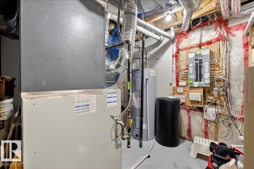 Dedicated utility area featuring a water heater, furnace, and electrical panel - 3936 Claxton Loop, Edmonton, AB - Indoor Photo Showing Basement