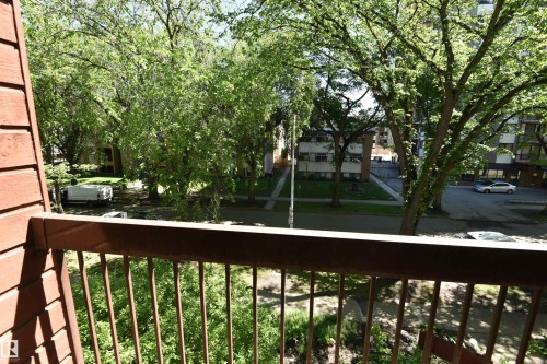 Balcony featuring a metal railing and a partial brick exterior - 21 10160 119 Street Nw, Edmonton, AB 