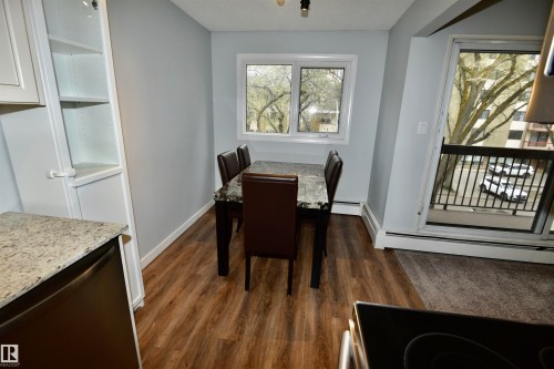 Dining area with wood-finish flooring and light gray walls - 21 10160 119 Street Nw, Edmonton, AB 