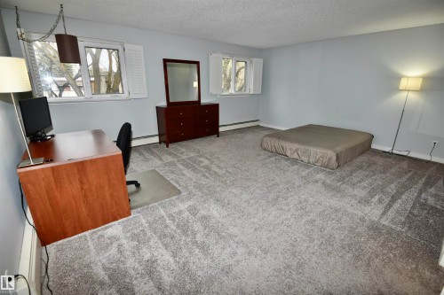 Spacious room featuring light gray walls and plush gray carpeting - 21 10160 119 Street Nw, Edmonton, AB 