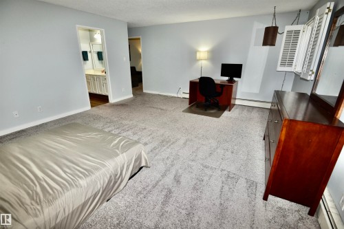 Spacious room featuring light gray walls and patterned carpeting - 21 10160 119 Street Nw, Edmonton, AB 