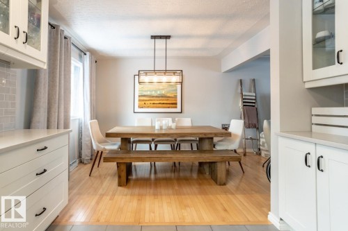 Wood-finish flooring featured throughout the dining area - 8239 93A Avenue, Edmonton, AB - Indoor Photo Showing Dining Room