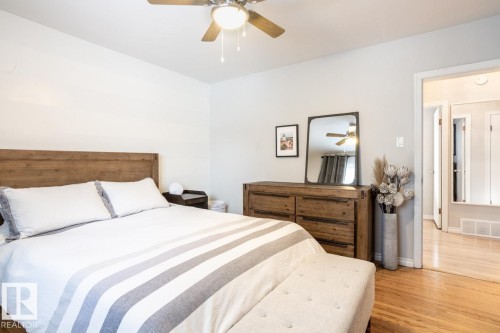 Bedroom featuring light wood-finish flooring and a ceiling fan with integrated lighting - 8239 93A Avenue, Edmonton, AB - Indoor Photo Showing Bedroom