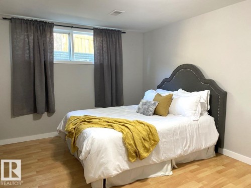 Room featuring light wood-finish flooring, white baseboards, and a neutral wall color - 8239 93A Avenue, Edmonton, AB - Indoor Photo Showing Bedroom