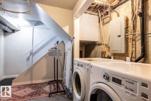 Dedicated laundry area with a washer and dryer, located near a finished stairway - 8239 93A Avenue, Edmonton, AB - Indoor Photo Showing Laundry Room