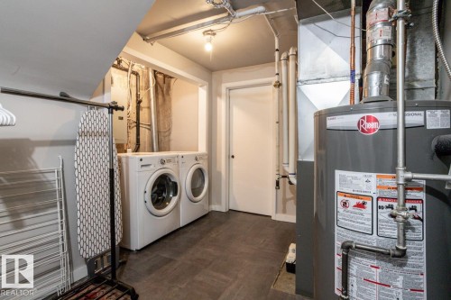Laundry area featuring a side-by-side washer and dryer, tile-finish flooring, a white door, and visible utility infrastructure - 8239 93A Avenue, Edmonton, AB - Indoor Photo Showing Laundry Room