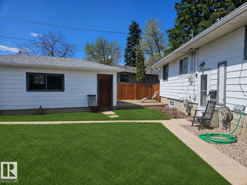 Expansive green lawn with a concrete pathway leading to a wood deck - 8239 93A Avenue, Edmonton, AB - Outdoor