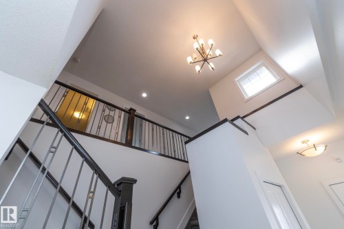 This property features a grand staircase with dark wood handrails and contemporary metal balusters - 14 Edgewater Terr North, St. Albert, AB - Indoor Photo Showing Other Room
