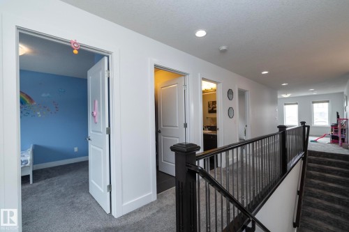 The upper level features a carpeted hallway with recessed lighting, white walls, and white trim - 14 Edgewater Terr North, St. Albert, AB - Indoor Photo Showing Other Room