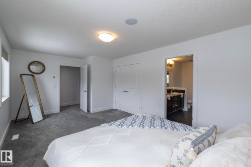 This room features grey carpeting, white walls, and a window providing natural light - 14 Edgewater Terr North, St. Albert, AB - Indoor Photo Showing Bedroom