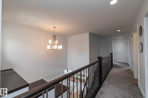 This property features a bright hallway with recessed lighting and a sophisticated chandelier - 14 Edgewater Terr North, St. Albert, AB - Indoor Photo Showing Other Room