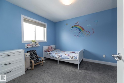 The room features blue walls, a window with a blind, and a light-colored ceiling - 14 Edgewater Terr North, St. Albert, AB - Indoor Photo Showing Bedroom