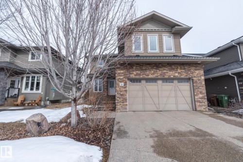 The property features a two-car garage, a stone facade, and a concrete driveway - 14 Edgewater Terr North, St. Albert, AB - Outdoor