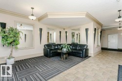 Lobby area featuring mixed-patterned flooring, wall-mounted mirrors, decorative sconces, and crown molding accents - 