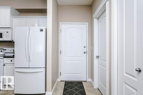 Entryway featuring a panel door with brushed nickel hardware - 323 16807 100 Avenue, Edmonton, AB - Indoor Photo Showing Other Room