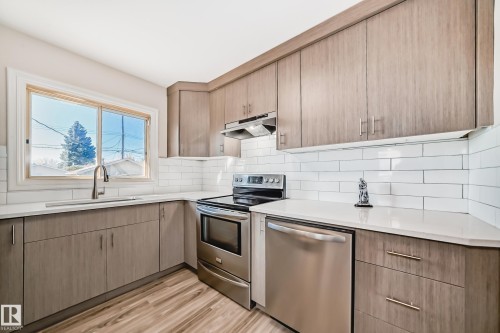 Contemporary kitchen featuring light wood-finish cabinetry and light countertops - 13124 83 Street, Edmonton, AB - Indoor Photo Showing Kitchen With Upgraded Kitchen