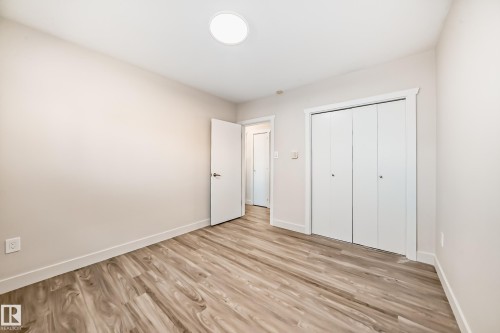 Room featuring wood-finish flooring, light-toned walls, and a circular ceiling light fixture - 13124 83 Street, Edmonton, AB - Indoor Photo Showing Other Room