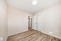 Room featuring wood-finish flooring, light-toned walls, white trim, and a flush-mount ceiling light fixture - 