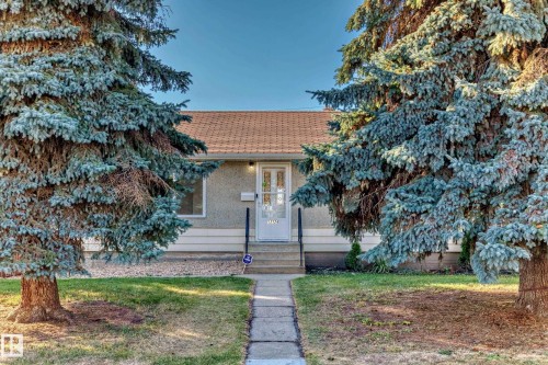 Front exterior featuring a light-colored stucco facade with white trim - 13124 83 Street, Edmonton, AB - Outdoor