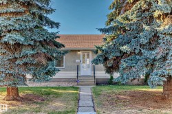 Front exterior featuring a light-colored stucco facade with white trim - 