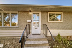 Concrete stairs with dark metal railings providing access to the front entry - 