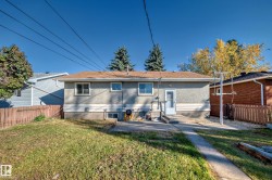Rear exterior with stucco siding and a brown shingle roof - 