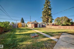 Expansive backyard featuring a manicured lawn, established landscaping, and mature trees - 