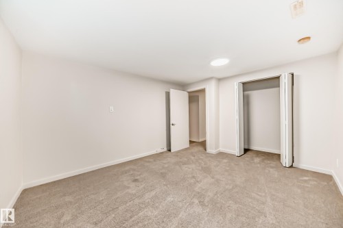 Spacious room featuring neutral carpeting, light-toned walls, and a ceiling-mounted light fixture - 13124 83 Street, Edmonton, AB - Indoor Photo Showing Other Room