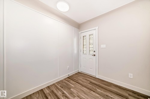 Entryway featuring a decorative glass panel door, wood-finish flooring, and a flush-mount ceiling light - 13124 83 Street, Edmonton, AB - Indoor Photo Showing Other Room