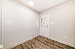 Entryway featuring a decorative glass panel door, wood-finish flooring, and a flush-mount ceiling light - 