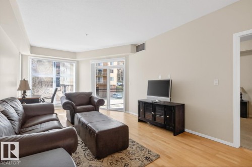 Living area featuring light wood-finish flooring, a full-height window with horizontal blinds, and a sliding glass door - 614 10503 98 Avenue, Edmonton, AB - Indoor Photo Showing Living Room
