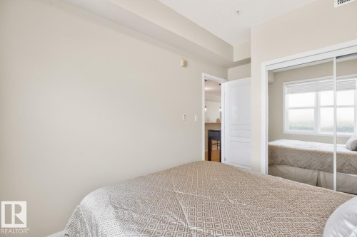 Bedroom featuring light neutral wall tones, a mirrored closet with sliding doors, and a window with horizontal blinds - 614 10503 98 Avenue, Edmonton, AB - Indoor Photo Showing Bedroom