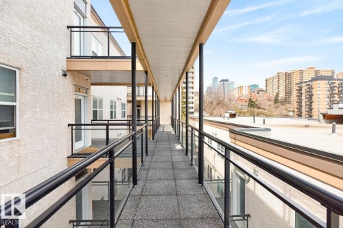 Outdoor walkway featuring a durable, textured surface and clear glass railings with black metal accents - 614 10503 98 Avenue, Edmonton, AB - Outdoor
