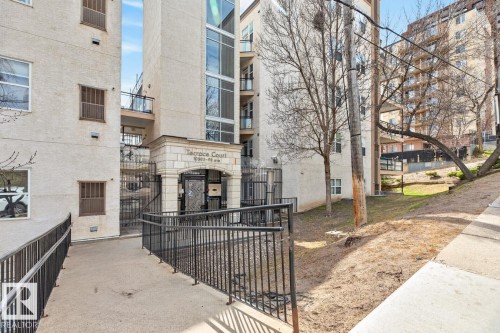 Exterior facade of a multi-story building featuring a prominent stone-clad entrance with "Terrace Court" signage - 614 10503 98 Avenue, Edmonton, AB - Outdoor