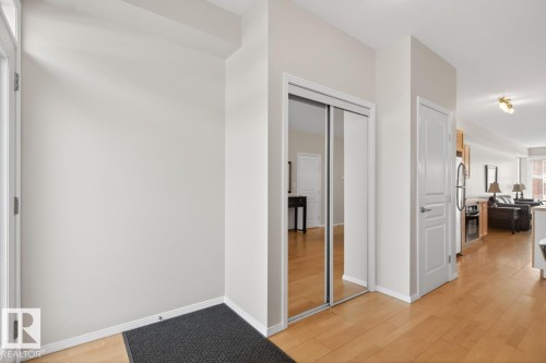 Entryway featuring wood-finish flooring, a mirrored closet, and a white paneled door - 614 10503 98 Avenue, Edmonton, AB - Indoor Photo Showing Other Room
