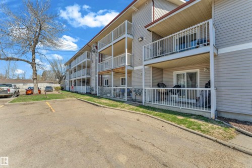 Multi-story building with neutral siding, individual balconies, and ground-floor patios - 101 10136 160 Street Nw, Edmonton, AB - Outdoor