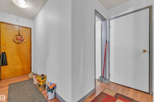 Hardwood-finish flooring extending through an entryway with a flush-mount ceiling light - 101 10136 160 Street Nw, Edmonton, AB - Indoor Photo Showing Other Room