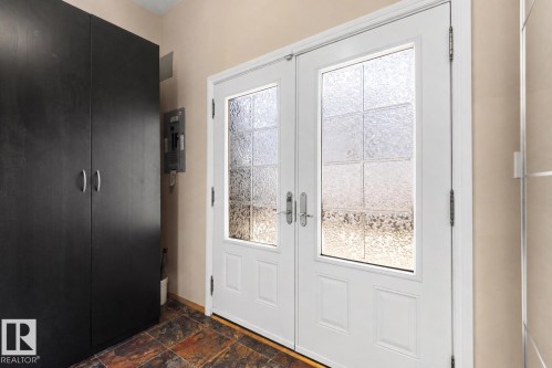 Double entry doors featuring textured glass panels and white frames - 9602 85 Street, Edmonton, AB - Indoor Photo Showing Other Room