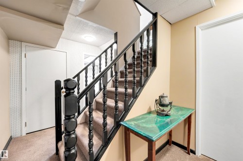 Carpeted stairway featuring dark wood banisters and balusters - 9602 85 Street, Edmonton, AB - Indoor Photo Showing Other Room