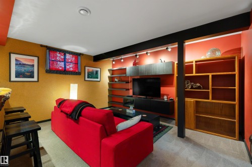 Lower-level entertainment space featuring track lighting, built-in shelving, a wood-finish bar counter, and recessed lighting - 9602 85 Street, Edmonton, AB - Indoor