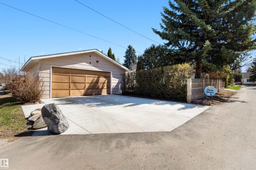 Detached garage with a paneled door and light-toned siding, complemented by a concrete driveway - 9602 85 Street, Edmonton, AB - Outdoor