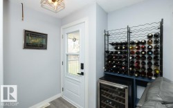Dedicated beverage storage area featuring a built-in wine rack and a wine refrigerator - 