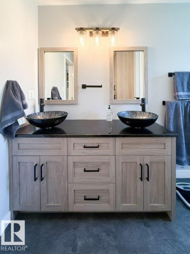 Dual vessel sinks with dark finish atop a dark countertop - 27132A Twp Rd 632, Rural Westlock County, AB - Indoor