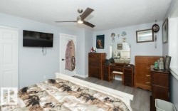 Spacious room featuring wood-finish flooring, a contemporary ceiling fan, and light blue wall tones - 